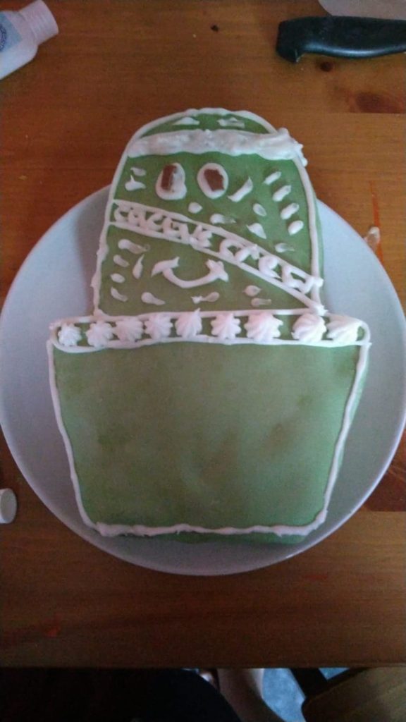 A cake shaped like a cactus with green frosting.